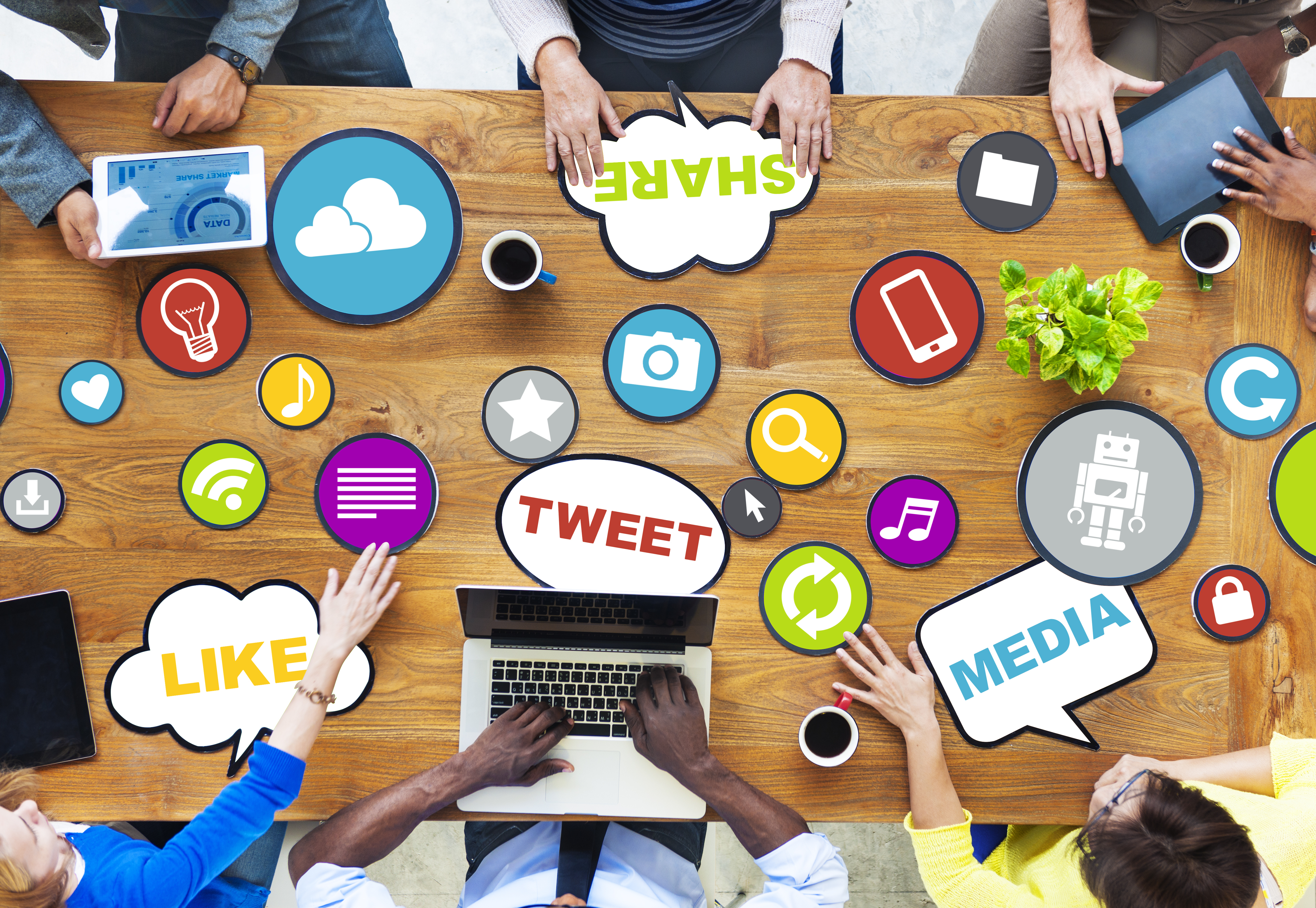 Social Media Marketing: Picture of team working at a table with various icons that represent technology and marketing